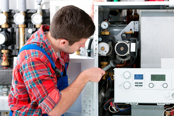 Heating technician repairing boiler controls in San Gabriel