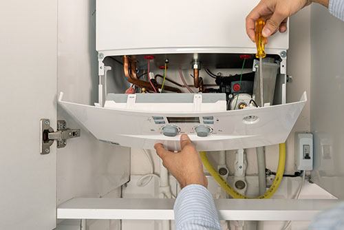 Heating technician repairing a residential boiler in San Gabriel