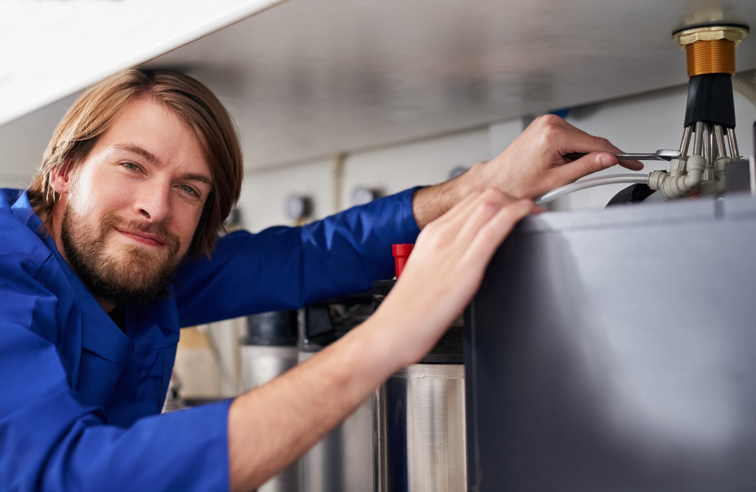 Technician servicing a residential water heater tank in San Gabriel