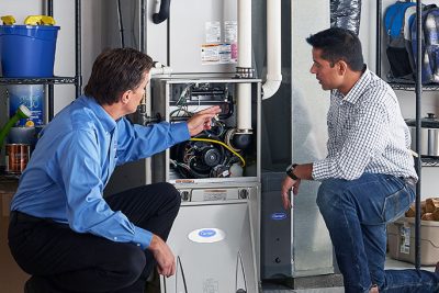 Technician evaluating a furnace for repair or replacement in San Gabriel